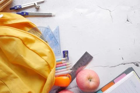 Back to school concept with yellow backpack and school suppliers on table Stock Photos