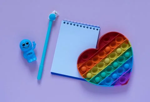 Back to school concept.Notepad, blue pen and antistress toy in the form of a Stock Photos