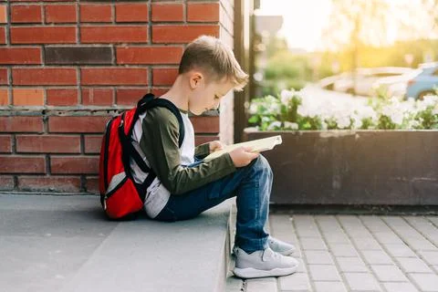 Back to school. Cute child with backpack, holding notepad and training books Stock Photos
