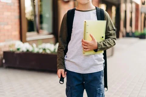 Back to school. Cute child with backpack holding notepad and training books Stock Photos