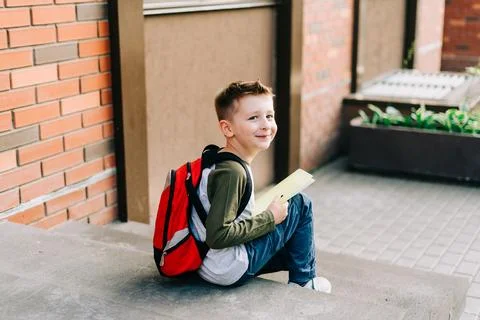 Back to school. Cute child with backpack, holding notepad and training books Stock Photos