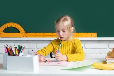 Back to school. Cute pupil girl drawing at the desk. Genius child, knowledge day Stock Photos