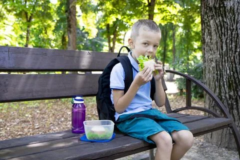 Back to school. An elementary school student has a sandwich after class.   Stock Photos