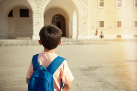 Back to school first day kid carrying backpack walking up school stairs Stock Photos
