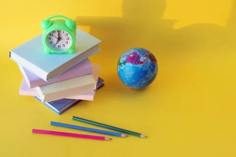 Back to school, globe, alarm clock, stack of books and pencils Stock Photos