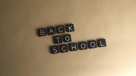 Back to school letter tiles message on a brown background Stock Footage 341323480