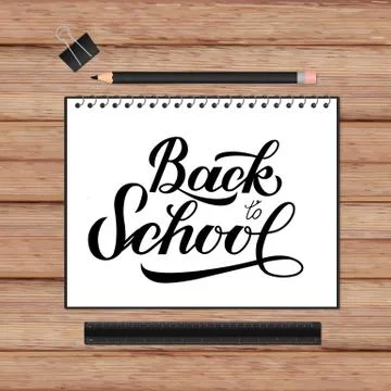 Back to school lettering hand written in a notebook. Wooden texture backgroun Illustrazione stock