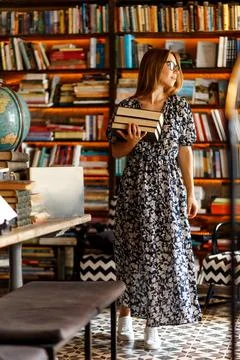 Back to school library concept. Student girl holding book on her hands on Stock Photos