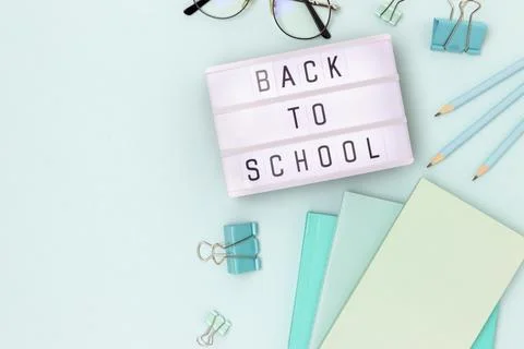 Back to school. Lightbox with letters and stationery on a blue background. Stock Photos