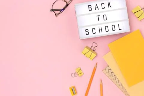 Back to school. Lightbox with letters and stationery on a pink background. Stock Photos