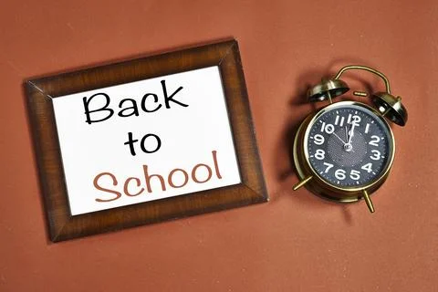Back to School Message In Frame With Vintage Alarm Clock On Orange Background Stock Photos