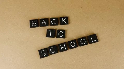 Back to school message on letter blocks with brown background Stock Photos