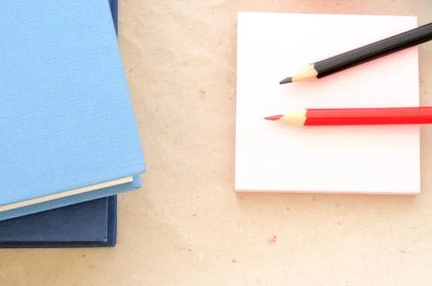 Back to school, minimal background, colored red and black pencils and books Stock Photos
