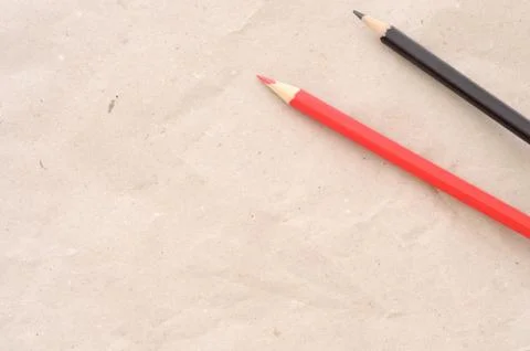Back to school, minimal background, a red pencil and a black pencil on brown  Stock Photos