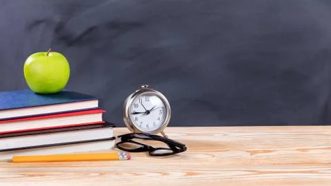 Back to school objects in front of erased black chalkboard Stock Photos