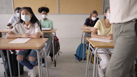 Back to school pandemic. The young students in protective masks learn in class Stock Footage 165140740