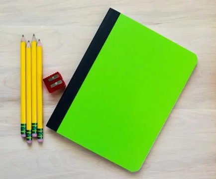 Back to school-pencils, sharpener and notebook with blank cover on a wooden desk Stock Photos