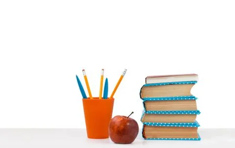 Back to school, pile of books and red apple on the white table with white bac Stock Photos