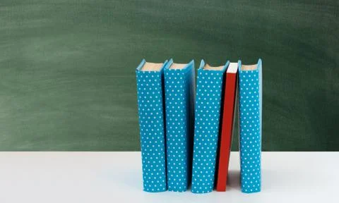 Back to school, pile of books with empty green school board background. Dista Stock Photos