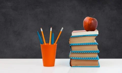 Back to school, pile of books with empty green school board background. Dista Stock Photos