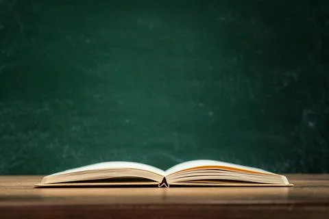 Back to school preparations with an open book on a wooden desk in front of a Foto stock