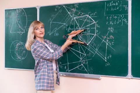 Back to school. The professor solves the problem at the blackboard Stock Photos