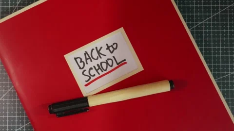 Back to School red notebook folder on wooden desktop Stock Footage 341269350