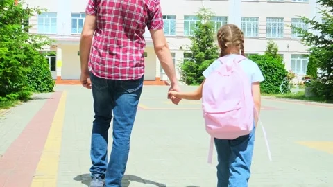 Back to school. Schoolgirl with backpack and father going to school first lesson Stock Footage 277677973