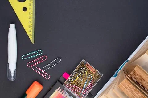 Back to school. Stationery on a black table. Office desk with copy space. Fla Stock Photos