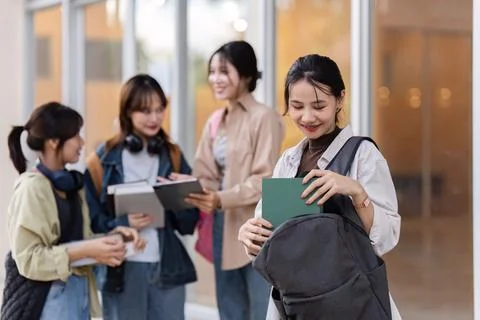 Back to school. students go to university. The woman take out a notebook from Stock Photos