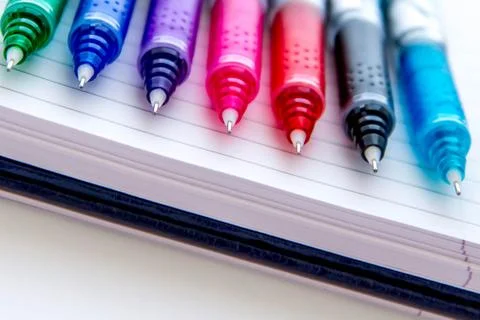 Back to school supplies, multi colored pens and a spiral notebook Stock Photos