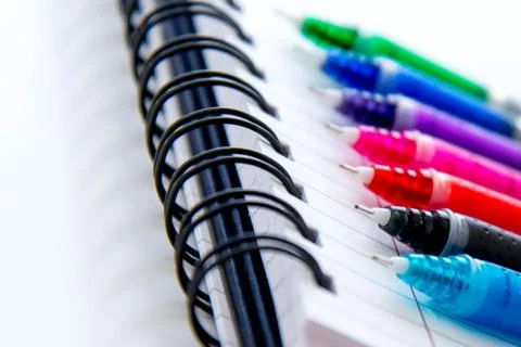 Back to school supplies, multi colored pens and a spiral notebook Stock Photos