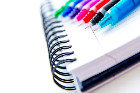 Back to school supplies, multi colored pens and a spiral notebook Stock Photos