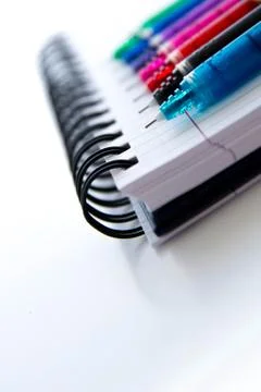 Back to school supplies, multi colored pens and a spiral notebook Foto stock