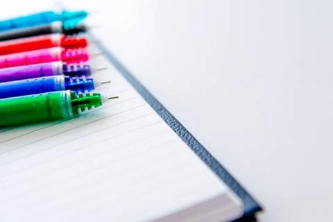 Back to school supplies, multi colored pens and a spiral notebook Stock Photos