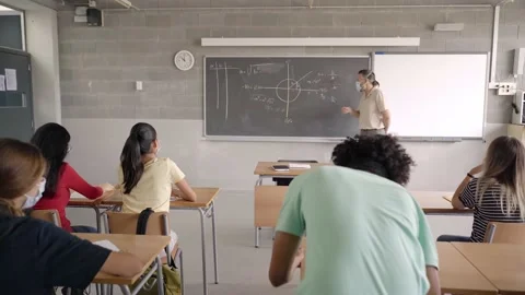 At back to school, the teacher and students wear protective masks due to the Stock Footage 158319313