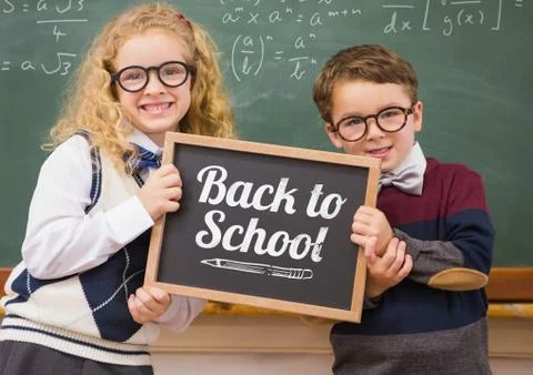 Back to school text on blackboard with two school kids Stock Photos