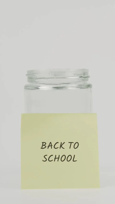Back to school text or word on yellow sticky note attached to glass jar Stock Footage 311680108