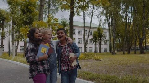 Back to school. Three Friends With Backpacks huging and laughing in front of Video stock 112669425