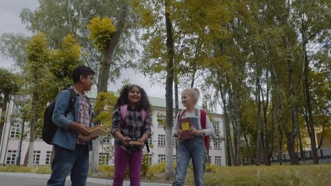 Back to school. Three Friends With Backpacks huging and laughing in front of Vídeo Stock 112669654