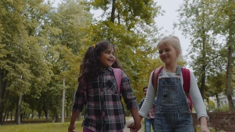 Back to school. Three Friends With Backpacks huging and laughing near school Stock Footage 113134038