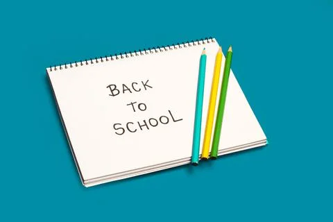 Back to school write in a white notebook on a turquoise background Stock Photos