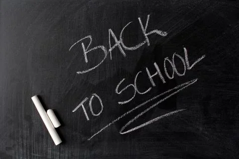 Back to school written in white chalk on a blackboard Stock Photos