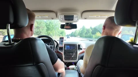Back-seat View of Moving Car with Driver, Passenger, and Traffic 库存影片 347683216