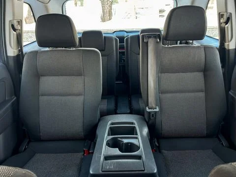 Back seats of a car are empty, showing the fabric and layout of the seats. Th Stock Photos