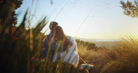 Back shot of affectionate millennial couple embracing sitting at park city Stock Footage 140736484