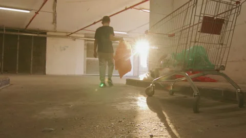 Back shot of boy with garbage bag going to recycling bin Stock Footage 225409903