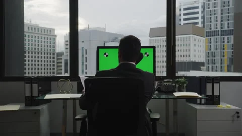 Back shot of Businessman using a computer with green screen and talking on .. Stock Footage 264242374