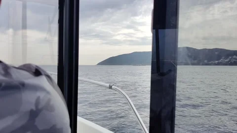 Back shot of a captain bobbing up and down over rough waves off the coats Stock Footage 244719795