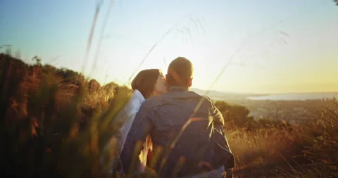 Back shot of couple in love hugging at nature hill viewing city sunrise summer Stock Footage 140736396